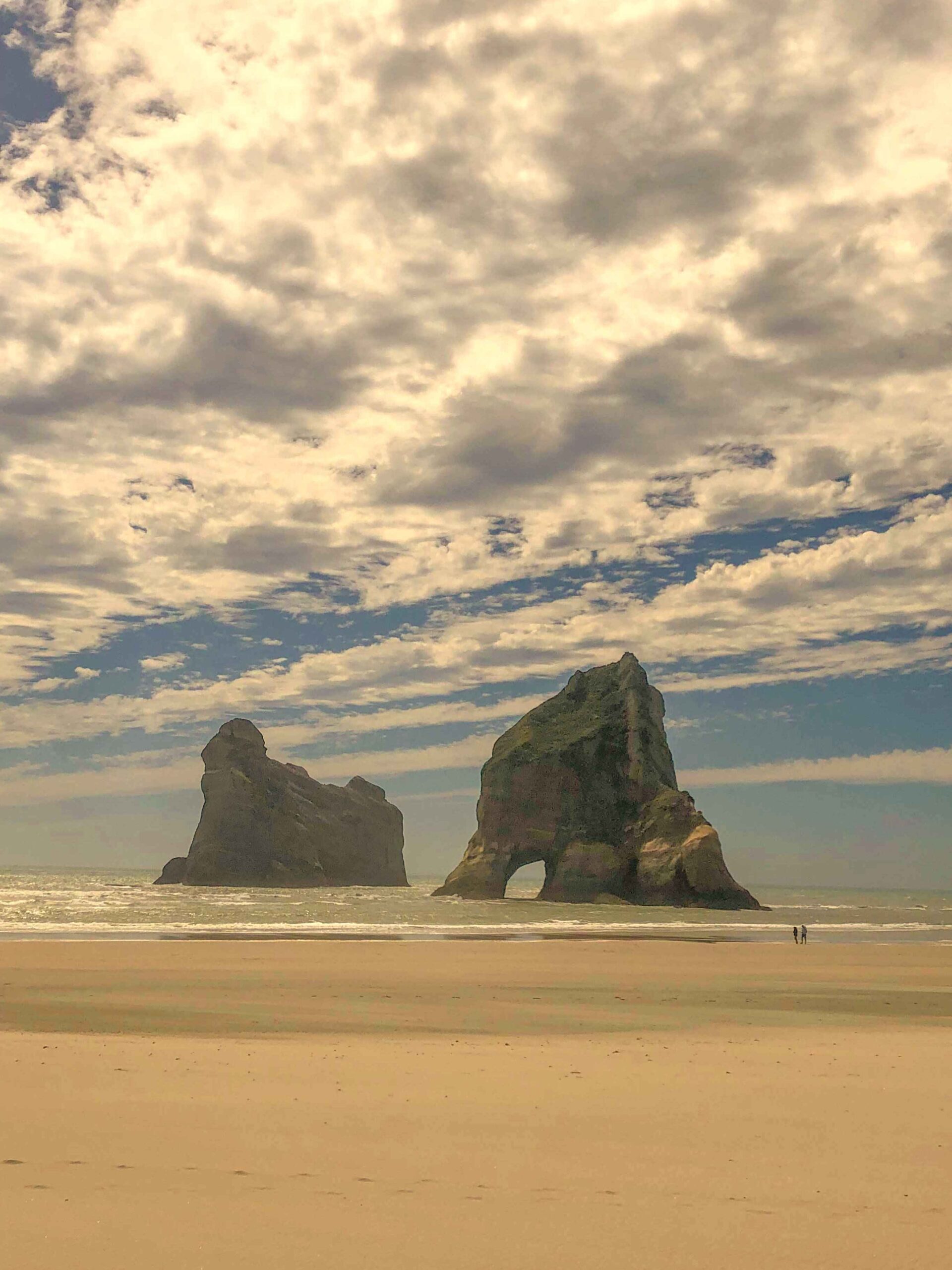 Archway Islands sea stacks at Wharariki Beach, Golden Bay, New Zealand, under a dramatic sky.