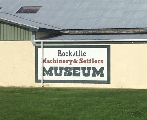 Exterior sign for Rockville Machinery & Settlers Museum displayed on the side of a building.