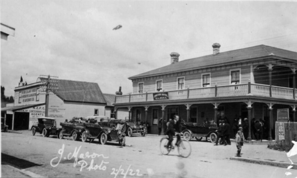 Black-and-white photo of Collingwood’s Commercial Hotel in 1922, with early cars, bicycles, and people outside.