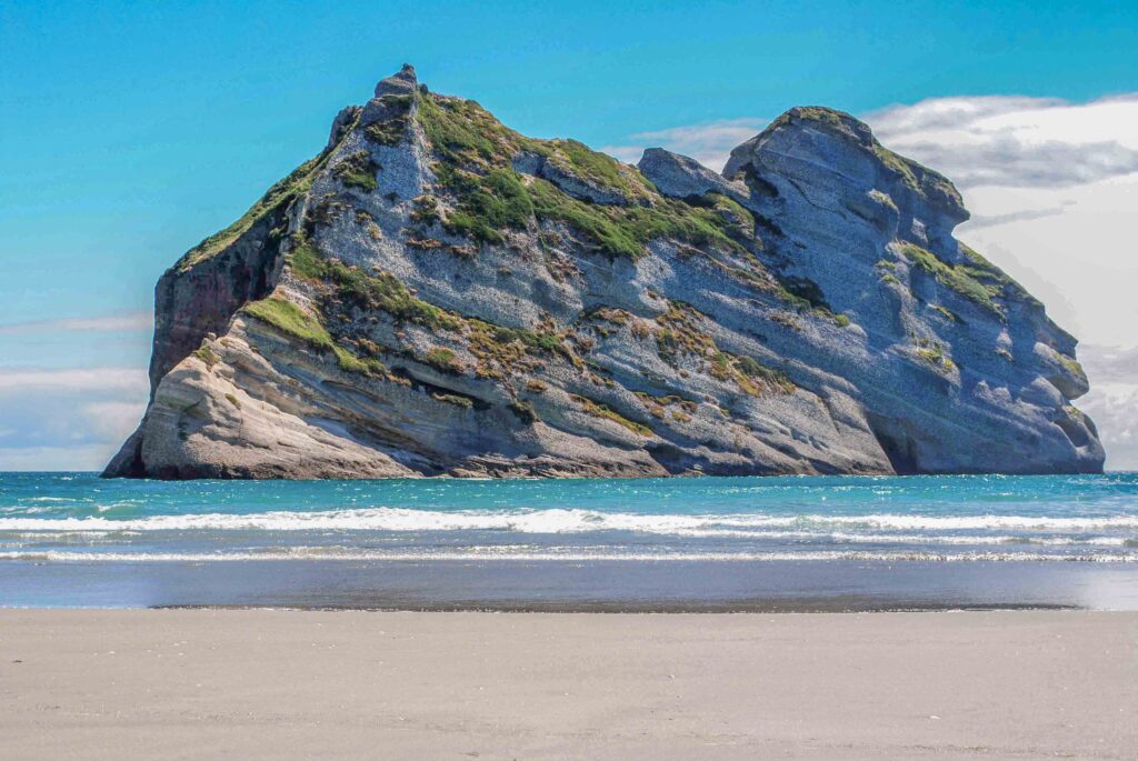 Archway Islands at Wharariki Beach, Golden Bay, New Zealand – dramatic sea arches and rock formations rising from the Tasman Sea at sunset.