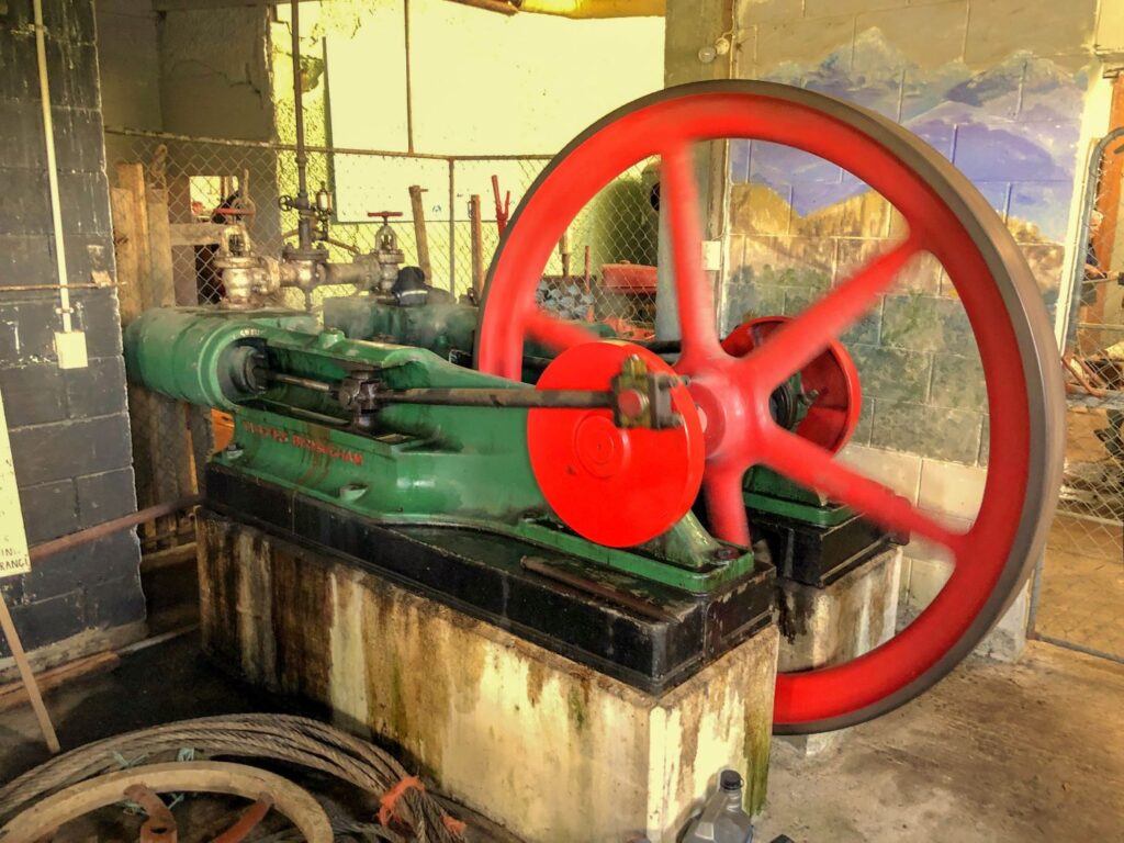 Historic steam engine with large red flywheel on display at the Rockville Steam Museum.
